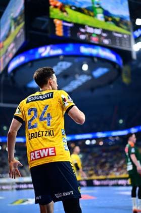 Handball, HBL, Rhein-Neckar Löwen - TSV Hannover-Burgdorf #6 Patrick Groetzki ( 24; Rhein Neckar Löwen) steht mit dem Rücken zur Kamera auf dem Spielfeld und beobachtet das Geschehen. Im Hintergrund sind Spieler von TSV Hannover Burgdorf sowie die Anzeigetafel der Arena zu sehen. Patrick Groetzki ( 24; Rhein Neckar Löwen) im Spielgeschehen Copyright: xMichaelxGelhardtx