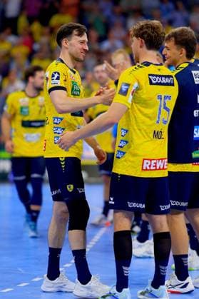 Patrick Groetzki ( 24; Rhein Neckar Löwen) und David Möré ( 15; Rhein Neckar Löwen) begrüßen sich mit einem Handschlag auf dem Spielfeld. Gino Steenaerts ( 14; Rhein Neckar Löwen) steht rechts daneben, im Hintergrund sind weitere Spieler der Rhein Neckar Löwen zu sehen. Patrick Groetzki ( 24; Rhein Neckar Löwen) begrüßt David Möré ( 15; Rhein Neckar Löwen)