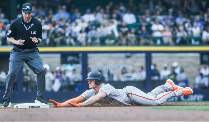 second base umpire Paul Clemons watches as San Francisco Giants third baseman Matt Chapman slides into second base after hitting an RBI double in the first inning of the MLB, Baseball Herren, USA game between the San Francisco Giants and the Milwaukee Brewers at American Family Field in Milwaukee, Wisconsin on Thursday, June 4, 2026.  MIL20260604808 TANNENxMAURY