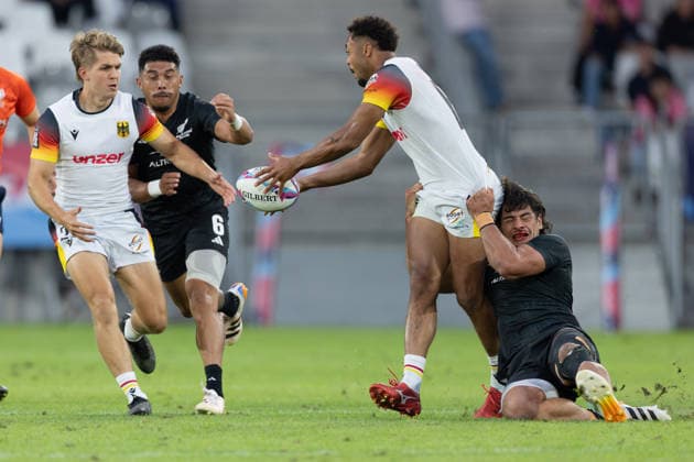 Neuseeland - Deutschland, SVNS Rugby World Championship, WM, Weltmeisterschaft Makonnen Amekuedi (Deutschland, 60) wird von Rob Rush (Neuseeland) gehalten, kann den Ball aber zu Michael Goedeke (Deutschland, 25) passen. Im Hintergrund Ngarohi McGarvey-Black (Neuseeland). Zweites Gruppenspiel der deutschen Mannschaft gegen die All Blacks Sevens aus Neuseeland. Drittes Turnier der SVNS World Championship, Siebener-Rugby WM vom 5. bis 7. Juni 2026 in Bordeaux (Frankreich). Tag 1, Gruppenspiele am 5. Juni 2026., Bordeaux Region Nouvelle-Aquitaine Frankreich Stade Atlantique