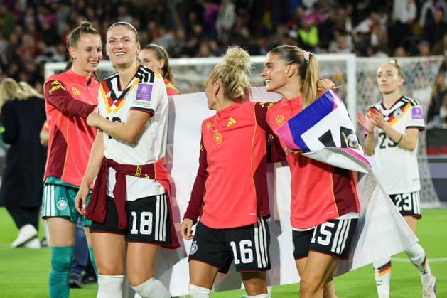 Köln, Deutschland: 05.06. 2026 - WM Qualifikationsspiel Deutschland vs. Norwegen Im Bild: v.li. Melissa Kössler Koessler (Deutschland), Linda Dallmann (Deutschland) und Selina Cerci (Deutschland) feiern mit dem offiziellen WM qualified Banner die gesicherte Teilnahme an der WM 2027 in Brasilien Copyright: HMBxMedia MadeleinexFantini