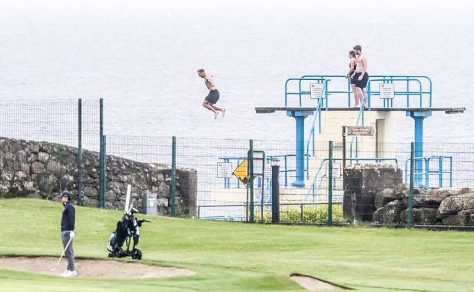 REPRO FREE *PRESS RELEASE NO REPRODUCTION FEE* EDITORIAL USE ONLY Connacht Men s Open Stroke Play Championship, Galway Golf Club, Galway 6 6 2026 A sea swimmer jumps off the Blackrock Diving Tower as Thomas Abom lines up a shot A sea swimmer jumps off the Blackrock Diving Tower as Thomas Abom lines up a shot 6 6 2026  Copyright: x INPHO TomxMaherx RDR_5393