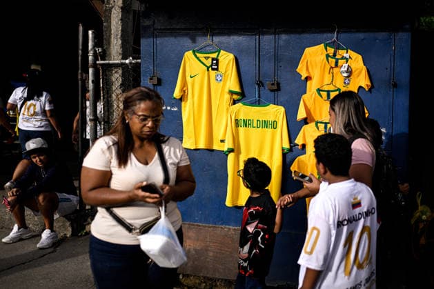 Former Brazilian soccer player Ronaldinho greets fans in Venezuela CARACAS, VENEZUELA – JUNE 6: People look at T-shirts featuring former Brazilian soccer player Ronaldinho, sold by street vendors during an exhibition match in the Petare neighborhood of Caracas, Venezuela, June 6, 2026. Maxwell Briceno Anadolu Caracas Venezuela. Editorial use only. Please get in touch for any other usage.  Copyright: x2026xAnadoluxMaxwellxBricenox