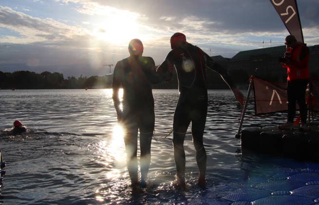 Ironman in Hamburg 2026: Der sehbehinderte Rob Sears (r.) mit seinem Guide Ant Munson (l.) beim Schwimmstart in der Binnenalster.