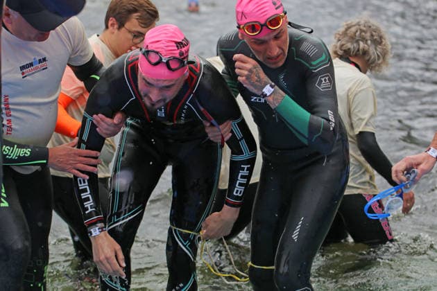 Ironman in Hamburg 2026: Der sehbehinderte Rob Sears (l.) mit seinem Guide Ant Munson (r.) beim Verlassen der Schwimmstrecke.