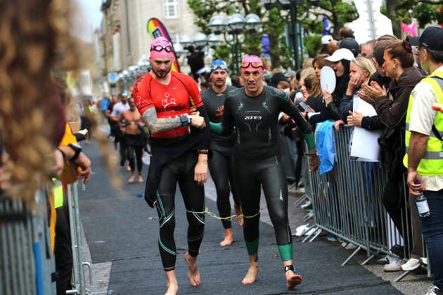 Ironman in Hamburg 2026: Der sehbehinderte Rob Sears (l.) mit seinem Guide Ant Munson (r.) sind nach dem Schwimmen auf dem Weg in die Wechselzone.