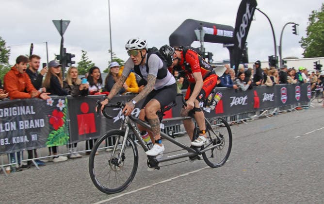Ironman in Hamburg 2026: Der sehbehinderte Rob Sears (h.) begibt sich mit seinem Guide Ant Munson (v.) auf die Radstrecke.
