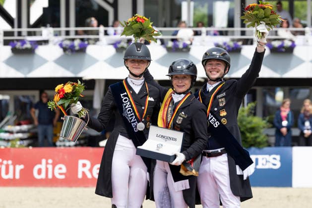 Isabell WERTH (GER, mi.) mit Semmieke ROTHENBERGER (GER, li.), und Raphael NETZ (GER, re.) bei der Siegerehrung, Freude, Jubel, Lachen, Dressur 03: Longines Grosser Optimum Preis, Deutsche Meisterschaften Grand Prix Kuer 2026, Dressur, Balve Deutschland, am 07.06.2026; Â