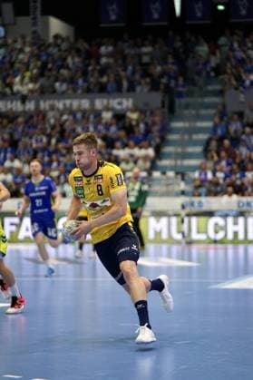 Tim Nothdurft ( 8; Rhein Neckar Löwen) läuft mit dem Ball in der Hand über das Spielfeld der SCHWALBE arena in Gummersbach. Im Hintergrund sind Spieler des VfL Gummersbach sowie die gefüllten Zuschauerränge zu sehen. Tim Nothdurft ( 8; Rhein Neckar Löwen) mit Ball in der SCHWALBE arena