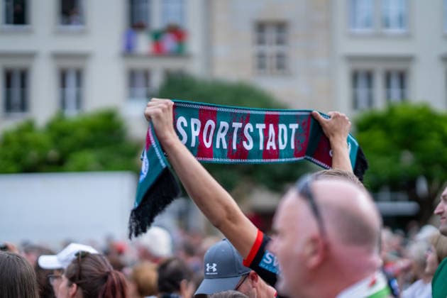 Deutschland: HBL DAIKIN Handball Bundesliga 2025 - 2026, Empfang im Rathaus und Meisterfeier des SC Magdeburg - Alter Markt (Magdeburg): Fans, Stimmung, Atmosphäre, Alter Markt, Innenstadt. Sportstadt, Schal