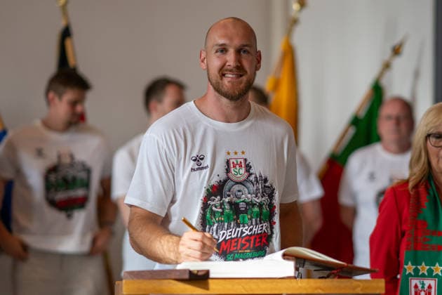 Deutschland: HBL DAIKIN Handball Bundesliga 2025 - 2026, Empfang im Rathaus und Meisterfeier des SC Magdeburg - Alter Markt (Magdeburg): Christian O Sullivan (SC Magdeburg, 24) bei der Eintragung in das Goldene Buch der Landeshauptstadt Magdeburg