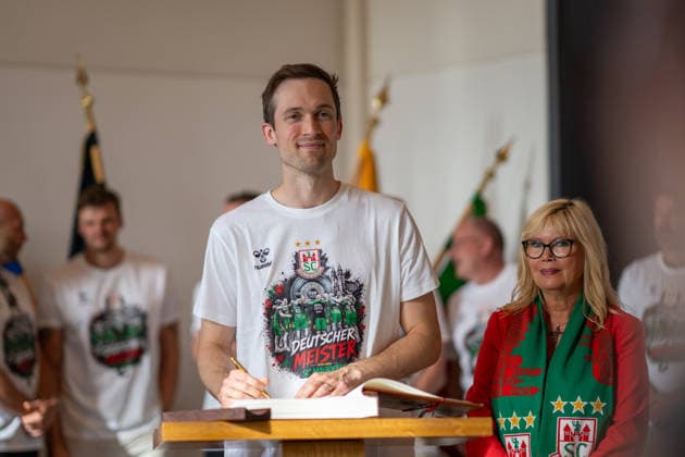 Deutschland: HBL DAIKIN Handball Bundesliga 2025 - 2026, Empfang im Rathaus und Meisterfeier des SC Magdeburg - Alter Markt (Magdeburg): Nikola Portner (SC Magdeburg, 80) bei der Eintragung in das Goldene Buch der Landeshauptstadt Magdeburg
