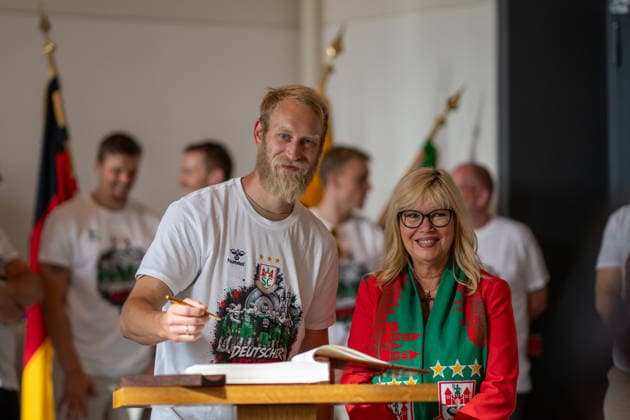 Deutschland: HBL DAIKIN Handball Bundesliga 2025 - 2026, Empfang im Rathaus und Meisterfeier des SC Magdeburg - Alter Markt (Magdeburg): Matthias Musche (SC Magdeburg, 6) bei der Eintragung in das Goldene Buch der Landeshauptstadt Magdeburg