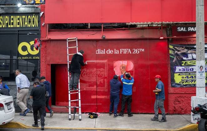 Fußball, Herren, Saison 2025 26, FIFA Word Cup 2026 in Mexiko, Kanada und USA, Mexiko-City zwei Tage (Ortszeit) vor dem Eröffnungsspiel, im Bild: gegenüber dem Aztekenstadion Estadio Banorte entfernen Arbeiter einer Bar den den Schriftzug der FIFA und der Coca Cola Werbung, 09.06. 2026,