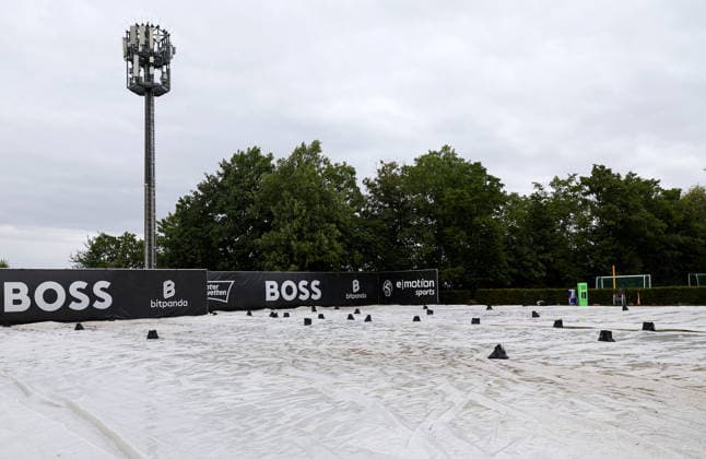 BAU 10.06.2026, Deutschland, Stuttgart, Tennis, BOSS Open 2026, Regen, Regenfeature, Feature, leere Ränge, Rasenabdeckung, Abdeckung, Übersicht, Mensch mit Regenschirm, Schirm
