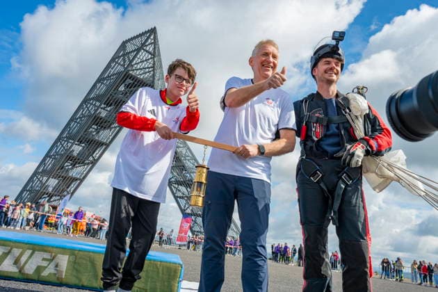 In Ensdorf startet am Donnerstag (11.6.2026) der FAckellauf der Special Olympics Nationalen Spiele für den LAndkreis Saarlouis. Der Fallschirmspringer Nils Kammer brachte die Flamme in einer Grubenlampe zur Bergehalde und überreichte sie an Landrat Patrik Lauer und Athlet Sascha Wollmer. Danach wurde die Flamme weitergereicht.