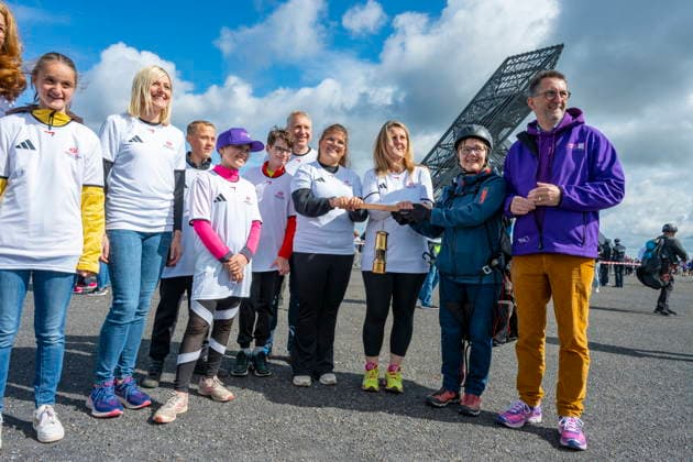 In Ensdorf startet am Donnerstag (11.6.2026) der FAckellauf der Special Olympics Nationalen Spiele für den LAndkreis Saarlouis. Der Fallschirmspringer Nils Kammer brachte die Flamme in einer Grubenlampe zur Bergehalde und überreichte sie an Landrat Patrik Lauer und Athlet Sascha Wollmer. Danach wurde die Flamme weitergereicht.