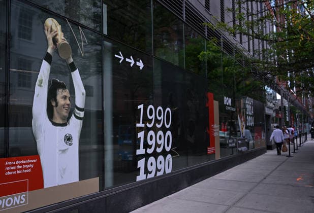 Fussball FIFA WM 2026 11.06.2026 Aussenansicht des German House of Soccer in Manhattan New York, Pre Opening beim Eroeffnungsspiel der WM 2026, Mexiko - Suedafrika, zweite Deutscher WM Sieg 1974 in Muenchen, Franz Beckenbauer mit Pokal