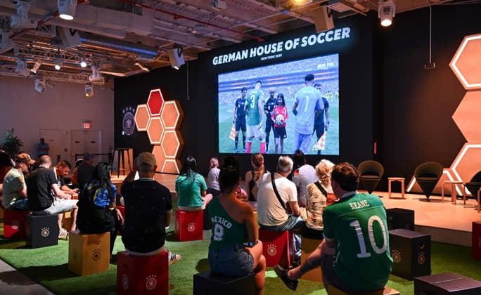 Fussball FIFA WM 2026 11.06.2026 German House of Soccer in Manhattan New York, Pre Opening beim Eroeffnungsspiel der WM 2026, Mexiko - Suedafrika. Fans schauen den Spielbeginn auf der Videowand.