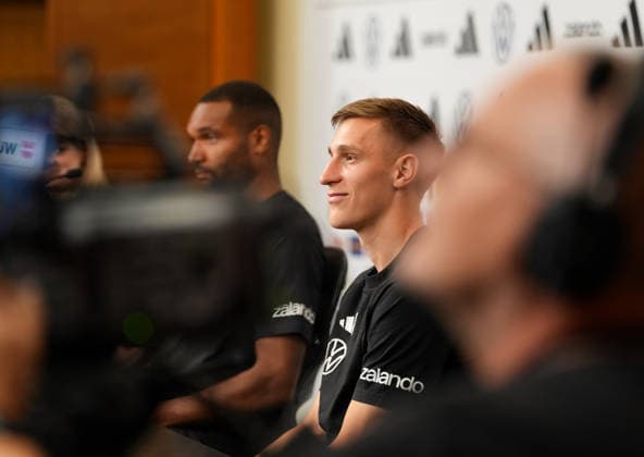 Ein Kameramann filmt Franziska Wuelle (Deutschland, Pressesprecherin), Jonathan Tah (Deutschland, 4) und Nico Schlotterbeck (Deutschland, 15) waehrend einer Pressekonferenz. USA, Deutsche Fussballnationalmannschaft, Pressekonferenz, Winston-Salem, 11.06.2026 USA, Deutsche Fussballnationalmannschaft, Pressekonferenz, Winston-Salem, 11.06.2026 Winston-Salem