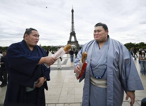 Sumo: Paris tournament Sumo grand champions Onosato (R) and Hoshoryu eat baguettes while sightseeing around Paris landmark the Eiffel Tower on June 11, 2026, ahead of a June 13-14 sumo tournament in the French capital.  A14AA0005618464P