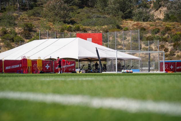 USA: Fussball FIFA World Cup, WM, Weltmeisterschaft, Fussball 2026 Training der Schweizer Nationalmannschaft im Basecamp San Diego (San Diego Jewish Academy, Carmel Valley, San Diego, Kalifornien): USA: Fussball FIFA World Cup 2026 Schweizer Nationalmannschaft Basecamp San Diego (Kalifornien): Trainingsgelände der Schweiz, Sportstätte, Innenansicht, Totale, Rasenplatz, Tor, Fussbälle, Hütchen, Trainingspuppen, Ausrüstung, Equipment, Fitnesszelt, Ergometer, Werbebande, SFV, Schweizer Fahne, We Are Switzerland, WM-Vorbereitung, Trainingscamp, Infrastruktur, San Diego, Kalifornien, USA, Symbolfoto. unten Froschperspektive