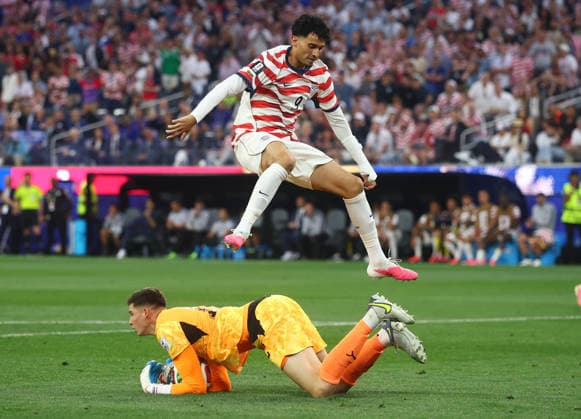 Ricardo Pepi of the United States leaps as Paraguay s goalkeeper Roberto Fernandez falls on the ball during the second half of a FIFA World Cup, WM, Weltmeisterschaft, Fussball match at SoFi Stadium in Los Angeles on Friday, June 12, 2026.  LAP20260612927 CHRISTIANxBRUNSKILL