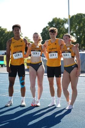 Philip Stroh (ASC Darmstadt) posiert gemeinsam mit drei weiteren deutschen Athleten in Germany-Trikots für ein Gruppenfoto auf der Tartanbahn. Die vier Starter der deutschen 4x100m-Staffel (GER I) stehen nebeneinander beim Meeting in Mannheim 2026. Philip Stroh und deutsches 4x100m-Team bei der 32. Bauhaus Junioren-Gala Mannheim