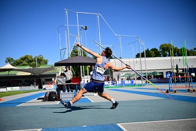 Tom Rutter ( 210) von Great Britain führt einen Speerwurf im Michael-Hoffmann-Stadion in Mannheim aus und befindet sich im Moment der maximalen Ausholbewegung. Der Athlet ist von hinten zu sehen, der Speer wird mit gestrecktem Arm nach vorne geführt. Tom Rutter ( 210) beim Speerwurf im Michael-Hoffmann-Stadion Mannheim