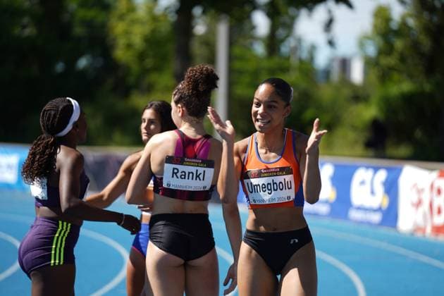 Joy Umegbolu ( 335, Switzerland) gestikuliert lächelnd auf der blauen Tartanbahn des Michael-Hoffmann-Stadions, während Timea Rankl ( 326, Switzerland) mit dem Rücken zur Kamera steht. Im Hintergrund sind weitere Athletinnen zu sehen. Joy Umegbolu ( 335) und Timea Rankl ( 326) nach dem Wettkampf bei der Bauhaus Junioren-Gala Mannheim