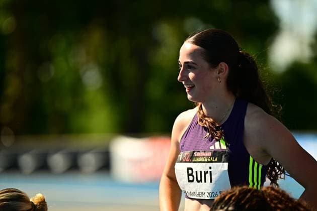 Xenia Buri aus der Schweiz lächelt nach ihrem Wettkampf bei der 32. Bauhaus Junioren-Gala im Michael-Hoffmann-Stadion in Mannheim. Die Athletin trägt ihr Startnummernschild mit dem Namen Buri und dem Veranstaltungslogo. Xenia Buri ( 310) bei der Junioren-Gala Mannheim 2026