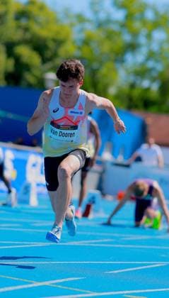 Sam Van Dooren (Belgium, 132) läuft mit voller Körperstreckung über die blaue Tartanbahn des Michael-Hoffmann-Stadions in Mannheim. Im Hintergrund bereitet sich ein weiterer Athlet in den Startblöcken vor. Sam Van Dooren ( 132) beim Sprint im Michael-Hoffmann-Stadion Mannheim