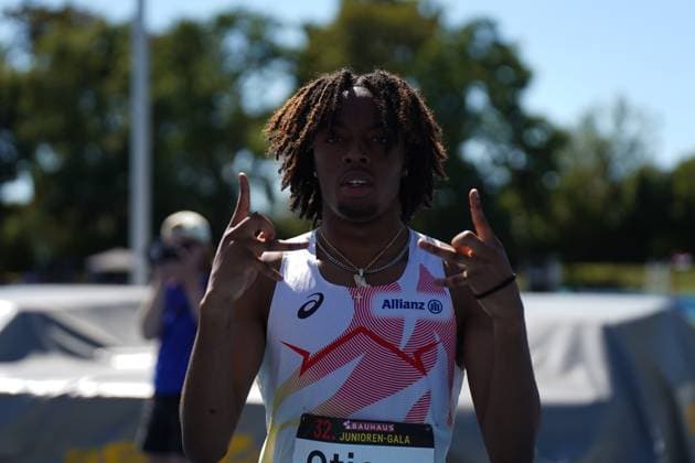 Bright Otiora (Belgium) posiert mit einer Geste in die Kamera nach seinem Wettkampf bei der 32. Junioren-Gala im Michael-Hoffmann-Stadion in Mannheim. Der Athlet trägt ein Asics-Trikot mit Allianz-Sponsoring und Goldketten. Bright Otiora feiert bei der 32. Junioren-Gala in Mannheim