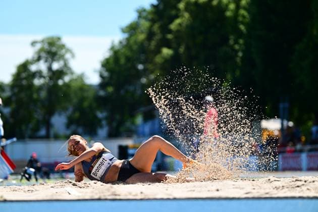 Antonia Bronnert von VfL Löningen landet im Sandkasten beim Dreisprung im Michael-Hoffmann-Stadion Mannheim, umgeben von einer Sandwolke. Der Moment der Landung ist mit voller Dynamik und sichtbarer Emotion eingefangen. Antonia Bronnert ( 386) bei der Dreisprung-Landung im Sand