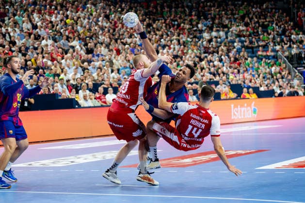 Köln, 12.05.2026, Handball, Herren, EHF Champions League Men 2025 26, Halbfinale, Aalborg Handball - FC Barcelona, Barca Timothey N Guessan (FC Barcelona, 19) im Zweikampf mit Felix Peter Möller (Aalborg Handball, 20) und Mads Hoxer Hangaard (Aalborg Handball, 14)