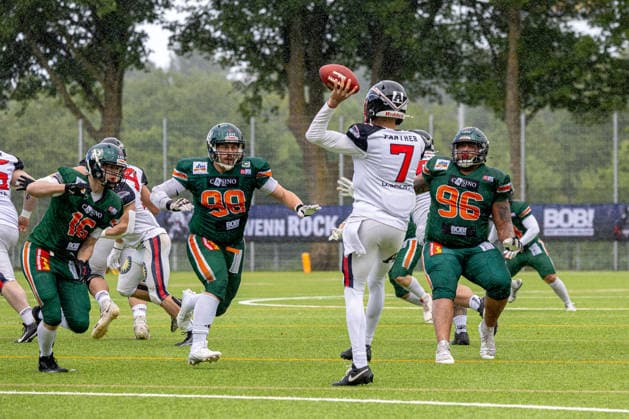 13.06.2026 American Football German Football League 2026 Kiel Baltic Hurricanes - Düsseldorf Panther (Kiel in Grün, Düsseldorf in Weiß) Isaiah Weed (Bildmitte) wird von den Kielern AJ Starcke, Tom Kamphausen (li.) und Joshua Köhnlein angegriffen Kiel Kilia-Stadion, Hasseldieksdammer Schleswig Holstein Deutschland