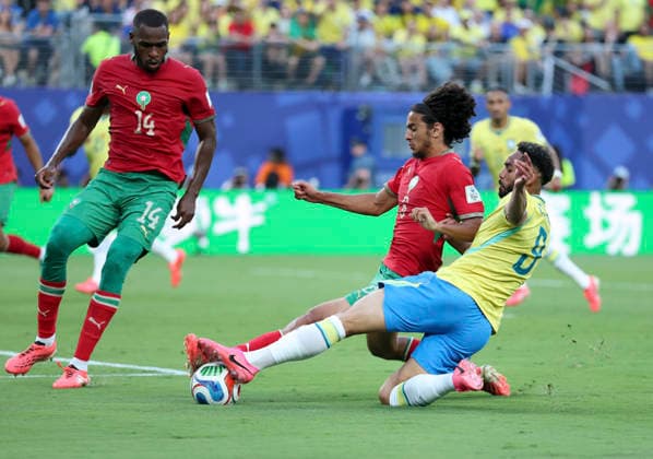 (260614) -- NEW YORK, June 14, 2026 -- Matheus Cunha (R) of Brazil vies with Ayyoub Bouaddi (C) of Morocco during the group C match between Brazil and Morocco at the 2026 FIFA World Cup, WM, Weltmeisterschaft, Fussball at New York New Jersey Stadium in New York, the United States, June 13, 2026. ) (SP)U.S.-NEW YORK-FOOTBALL-FIFA WORLD CUP-GROUP C-BRA VS MAR CaoxCan 