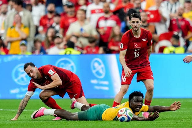 Australia v Turkiye - FIFA World Cup, WM, Weltmeisterschaft, Fussball 2026 - Group D VANCOUVER, CANADA - JUNE 13: Ismail Yuksek (16), and Hakan Calhanoglu (C) of Turkiye in action against Nestory Irankunda (ground) of Australia during the 2026 FIFA World Cup First Stage Group D match between Australia and Turkiye at BC Place Stadium in Vancouver, Canada on June 13, 2026. Ercin Erturk Anadolu British Columbia Canada. Editorial use only. Please get in touch for any other usage.  Copyright: x2026xAnadoluxErcinxErturkx