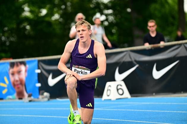 Jayden Parkin (South Africa, 360) kniet nach seinem Lauf auf der blauen Tartanbahn des Michael-Hoffmann-Stadions in Mannheim. Das Startnummernschild zeigt seinen Namen, im Hintergrund sind Nike-Werbebanden und Zuschauer zu sehen. Jayden Parkin ( 360) bei der Junioren-Gala in Mannheim