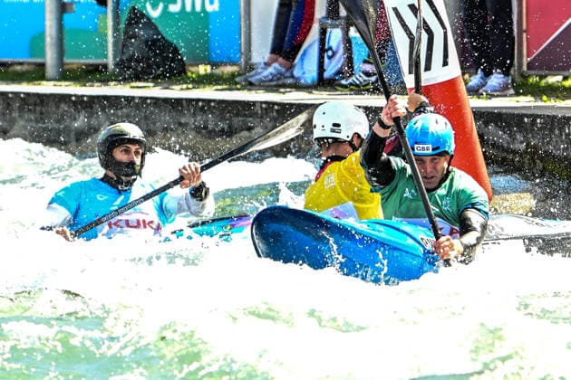 ICF Canoe Slalom World Cup - 14.06.2026, Eis Kanal, Augsburg A fierce battle at the final gate between David Llorente (blue) (ESP) , Joseph Clarke (green) (GBR) and Gabriel de Coster (yellow) (BEL), Augsburg, 14.06.2026 - Canoe World Cup, Kayak Cross Elimination, Augsburg, Eis Kanal