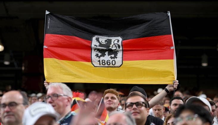 Fussball FIFA WM 2026 Vorrunde Gruppe E in Houston Deutschland - Curacao 14.06.2026 Deutschland Fan mit Fahne und dem TSV 1860 Muenchen Logo