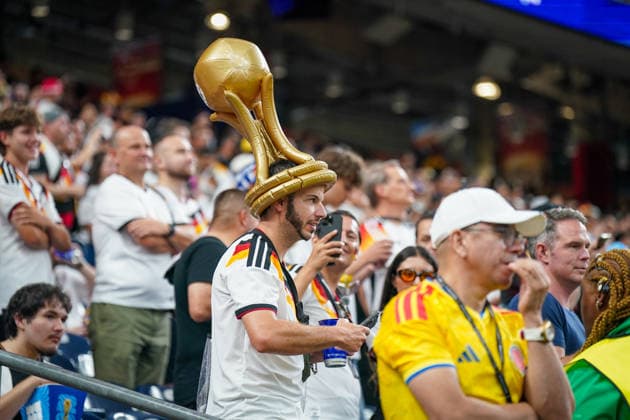 USA: Fussball FIFA World Cup, WM, Weltmeisterschaft, Fussball 2026 Gruppe E Deutschland vs Curacao Houston Stadium: Ein Fan der deutschen Nationalmannschaft trägt während der FIFA-Weltmeisterschaft 2026 im SoFi Stadium einen auffälligen Hut in Form der WM-Trophäe. Der Anhänger im Deutschland-Trikot steht zwischen Zuschauern verschiedener Nationen auf den Rängen. Im Vordergrund ist zudem ein Fan Kolumbiens zu sehen. Fankultur, Deutschland, DFB, WM 2026, FIFA World Cup, Supporter, Zuschauer, Atmosphäre, SoFi Stadium, Inglewood, Los Angeles, Fußball, Sportevent. *** USA Soccer FIFA World Cup 2026 Group E Germany vs. Curaçao Houston Stadium A fan of the German national team wears an eye-catching hat shaped like the World Cup trophy during the 2026 FIFA World Cup at SoFi Stadium. The supporter, wearing a Germany jersey, stands among spectators from various nations on theIn the foreground, a Colombia fan can also be seen. Fan culture, Germany, DFB, 2026 World Cup, FIFA World Cup, supporters, spectators, atmosphere, SoFi Stadium, Inglewood, Los Angeles, soccer, sporting event,detected_source_language Copyright: xJOERANxSTEINSIEKx
