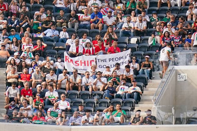 USA: Fußball FIFA World Cup, WM, Weltmeisterschaft, Fussball 2026 Gruppenphase Gruppe G Iran vs Neuseeland SoFi Stadium (Inglewood, Los Angeles County, Kalifornien): Iranische Fans verfolgen das WM-Spiel von den Tribünen aus und präsentieren ein Banner mit der Aufschrift Rashid The People™s Goalkeeper. Die Botschaft unterstützt den ehemaligen iranischen Nationaltorhüter Rashid Mazaheri, der nach regimekritischen Äußerungen inhaftiert wurde und dem nach Angaben von Unterstützern die Todesstrafe droht. Das Motiv verweist auf Solidarität, Menschenrechte und politische Botschaften im Umfeld der FIFA-Weltmeisterschaft 2026.