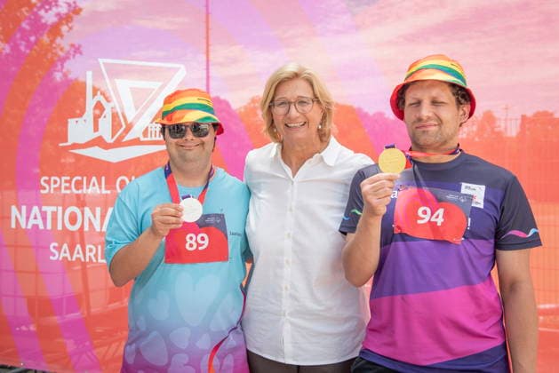 17.06.2026, Saarland, Saarbrücken. Ministerpräsidentin Anke Rehlinger besucht am Mittwoch die Leichtathletikwettkämpfe der Special Olympics im Stadion am Kieselhumes hier mit den AWO Medaillengewinnern Emre Atilgan (li.) und Pierre Verwaayen (re.)