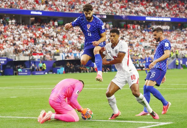 Croatia s goalkeeper Dominik Livakovic makes a save as teammate Josko Gvardiol (4) leaps high past England s Jude Bellingham in the first half during a FIFA World Cup, WM, Weltmeisterschaft, Fussball match at AT&T Stadium in Dallas, Texas, on Wednesday, June 17, 2026.  DAL20260617912 CHRISTIANxBRUNSKILL