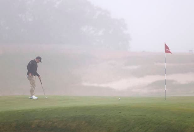 Alejandro Tosti of Argentina stands on the 1st green as thick fog causes a delay in play during the first round of the 126th U.S. Open Golf Championship at Shinnecock Hills Golf Club in Southampton, NY, on Thursday, June 18, 2026.  NYC20260618803 JOHNxANGELILLO