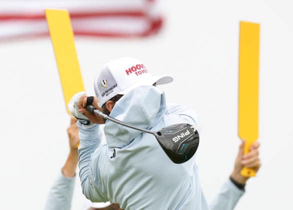 A gust of wind blows the hood from a hoodie into the face of Chase Kyes as he tees off on the 14th hole during the first round of the 126th U.S. Open Golf Championship at Shinnecock Hills Golf Club in Southampton, NY on Thursday, June 18, 2026.  NYC202606182001 JOHNxANGELILLO