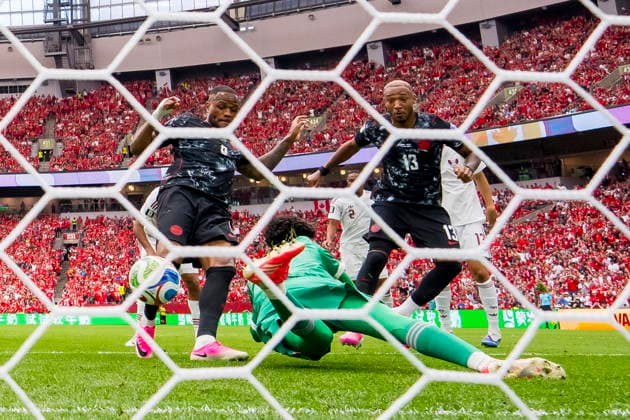FIFA World Cup, WM, Weltmeisterschaft, Fussball 2026 - Group B - Canada vs Qatar Canada forward Cyle Larin (R) scores past Qatar goalkeeper Mahmud Abunada (C) as teammate Derek Cornelius (R) looks on during the FIFA World Cup 2026 group stage match between Canada and Qatar in Vancouver, Canada, 18 June 2026. VANCOUVER Canada  Copyright: xBOBxFRIDx