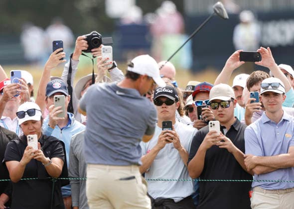 Spectators watch as Rory McIlroy of Northern Ireland takes practice swings before hitting a tee shot on the 5th hole in the second round of the 126th U.S. Open Golf Championship at Shinnecock Hills Golf Club in Southampton, NY on Friday, June 19, 2026.  NYC202606191012 JOHNxANGELILLO