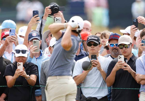Spectators watch as Rory McIlroy of Northern Ireland takes practice swings before hitting a tee shot on the 5th hole in the second round of the 126th U.S. Open Golf Championship at Shinnecock Hills Golf Club in Southampton, NY on Friday, June 19, 2026.  NYC202606191014 JOHNxANGELILLO